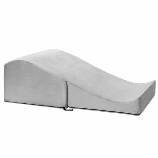 The Liberator Flip Ramp Convertible Sex Positioning Furniture is a gray, foam wedge with a gentle incline and curved top that discreetly doubles as an ottoman, providing ergonomic support and comfort. Shown here with a soft fabric cover on a white background.