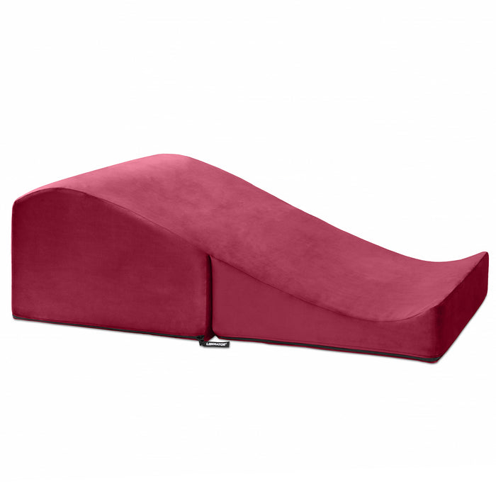 The Liberator Flip Ramp Convertible is a red, wedge-shaped foam positioning aid with a gradual incline for ergonomic support and comfort, designed to discreetly blend into your space. Shown here on a plain white background.