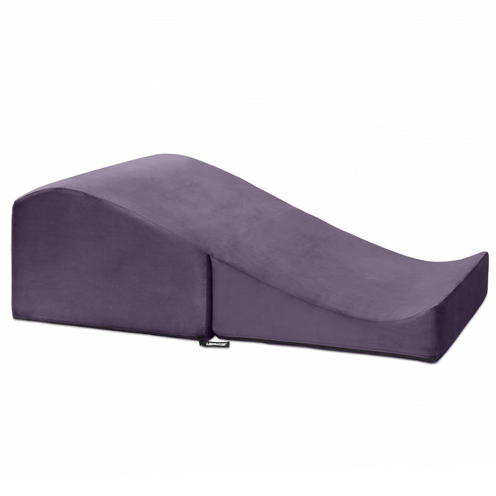 The Liberator Flip Ramp Convertible Sex Positioning Furniture is a wedge-shaped purple pillow with a gentle incline, designed for ergonomic support as a discreet ottoman or versatile sex ramp, shown on a white background.