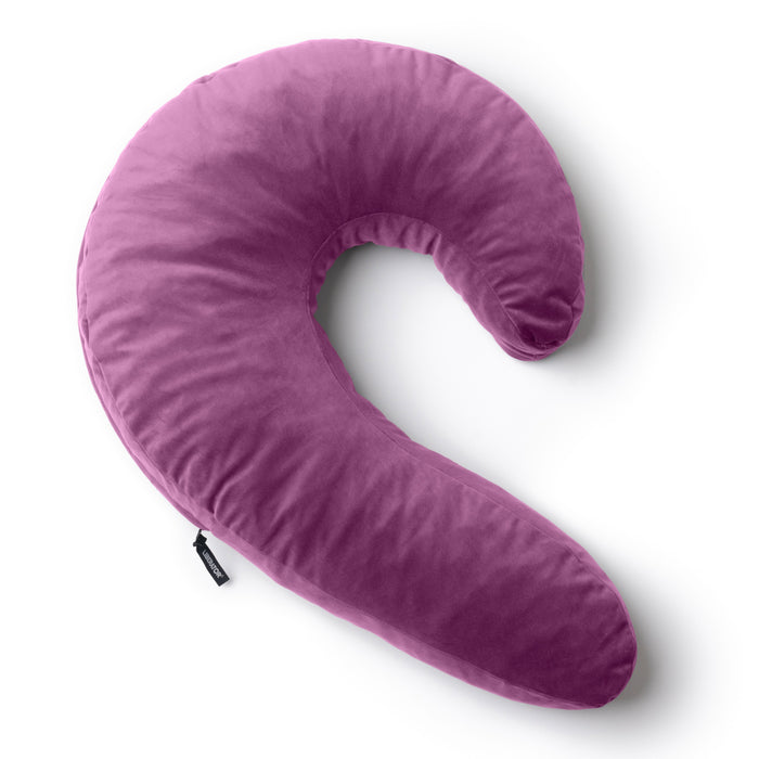 The Liberator Lune Snuggle Pillow with Vibrator Pocket, featuring a pink crescent shape and soft velvety texture, is displayed on a white background.