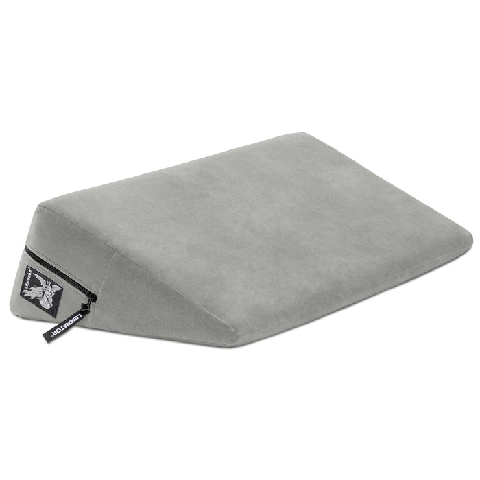The Liberator Wedge 24 Inches is a gray, wedge-shaped sex pillow with a soft cover, visible zipper, and small side tag—designed to provide enhanced comfort and deeper angles during intimacy.