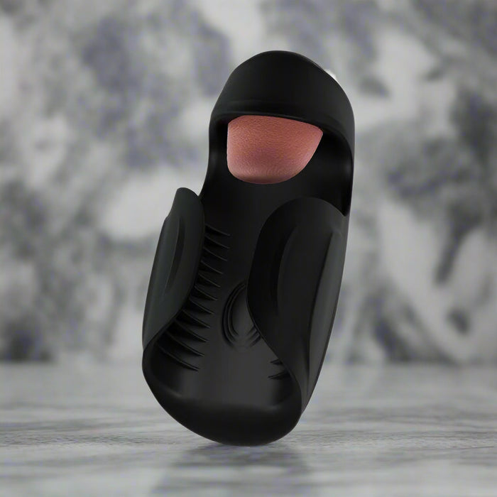 The Lickety Split Rechargeable Vibrating Thumping Stroker Silicone by Blush is a sophisticated black silicone sleeve crafted for ultimate pleasure. It showcases an open-ended design with a textured inner lining and multiple vibrating speeds, delivering ergonomic enhancements for personalized sensations.
