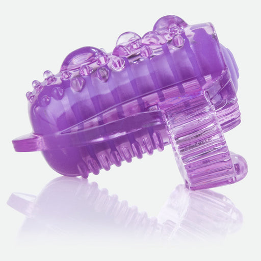 A close-up of the Lingo Vibrating Tongue Ring for Oral Play in purple silicone, featuring textured bumps and ridges for enhanced sensation, displayed on a reflective surface.