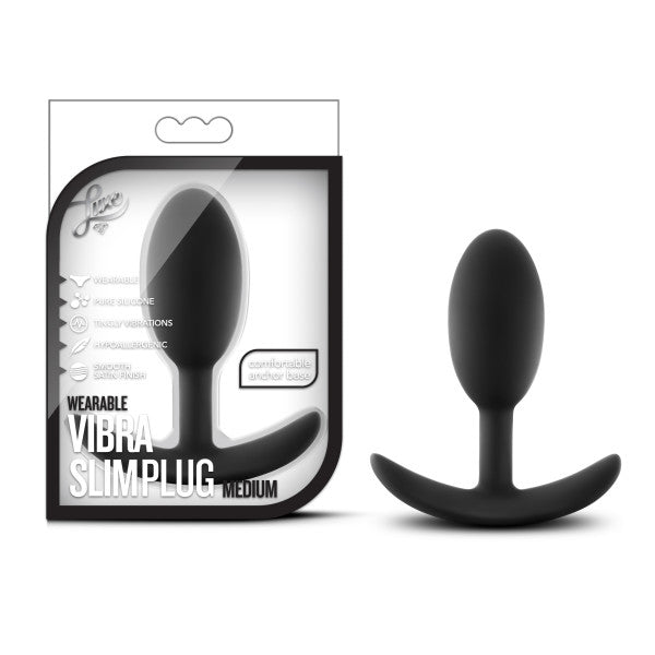 An image of the Luxe Medium Wearable Silicone Vibra Slim Plug - Black by Blush. The black silicone anal plug is displayed next to its packaging, which highlights features such as wearability, multiple vibration settings, and a comfortable anchor base.
