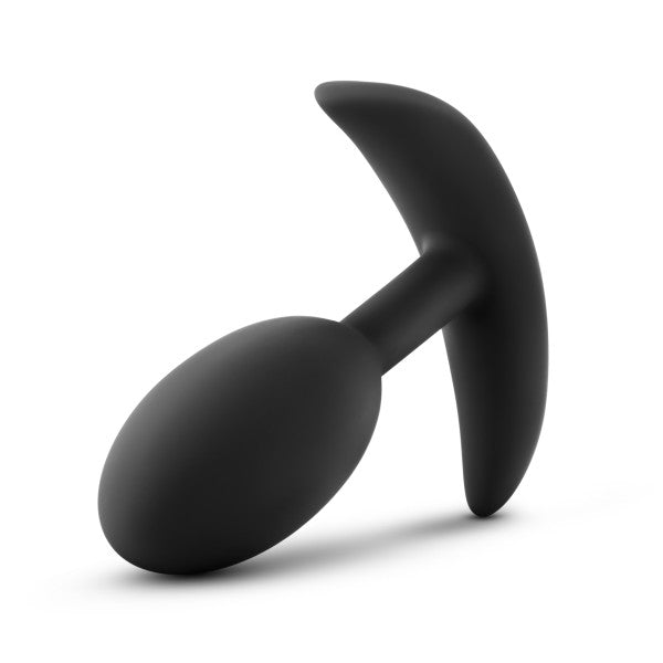 The Luxe Medium Wearable Silicone Vibra Slim Plug - Black by Blush is a black silicone anal plug featuring a tapered, rounded tip and an ergonomic T-shaped base for safe and comfortable use. Its smooth material and sleek, minimalistic shape make it perfect for discreet enjoyment.