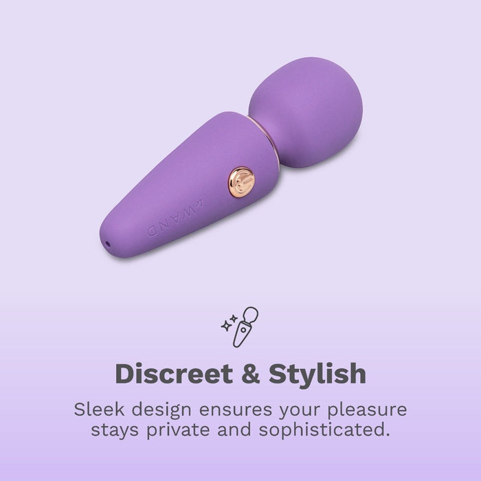 The Le Wand Micro Powerful Pocket Sized Wand, in purple with a gold button, rests on a light purple background above the words “Discreet & Stylish,” highlighting its sleek, private, and sophisticated design.
