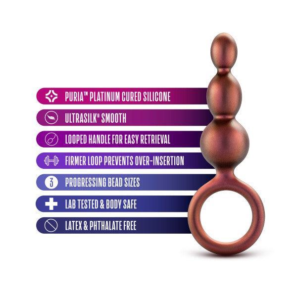 The Blush Matrix First Time Soft Silicone Beaded Anal Beads with Finger Loop is displayed next to six icons and descriptions, emphasizing its features: Puria platinum cured silicone, Ultrasilk smooth texture, looped handle for easy retrieval, firmer loop to prevent over-insertion, lab-tested & body-safe materials, and being latex- & phthalate-free.
