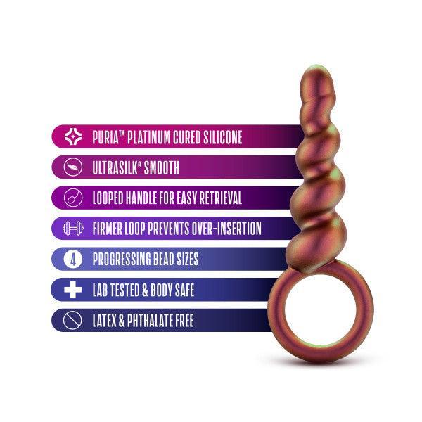 The Matrix First Time Soft Silicone Spiral Anal Beads with Finger Loop by Blush are displayed against a white background. Accompanying the product image are six icons with text: "Puria™ Platinum Cured Silicone," "Ultrasilk® Smooth," "Looped Handle for Easy Retrieval," "Proper Loop Prevents Over-Insertion," "4 Progressive Bead Sizes," and "Lab Tested & Body Safe.