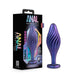 A product image featuring the Matrix Swirl Bling Butt Plug with Sparkly Heart Base by Blush. The silicone plug, boasting a sleek, ribbed design, is shown in a blue and purple metallic finish with a heart-shaped base. The product's packaging is black with colorful accents and detailed information on the front.