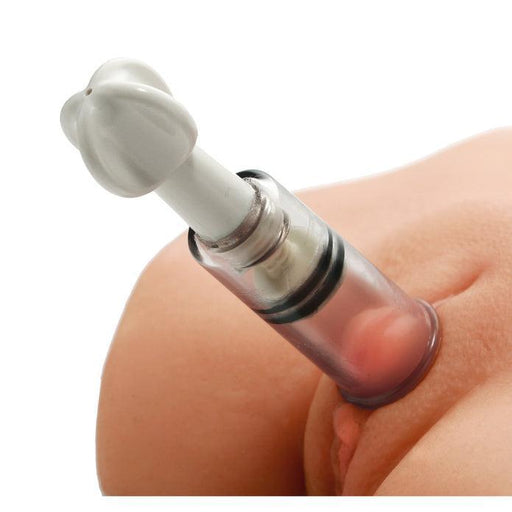 A close-up of the Max Twist Triplets Nipple and Clit Suckers by XR Brands applied to a person's skin, creating a vacuum. The discreet stimulation is evident as the device, with its transparent body and white, flower-shaped pump at the top, slightly raises the skin underneath due to the vacuum effect.