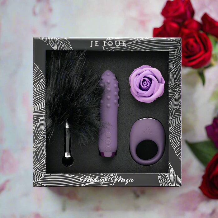 The "Midnight Magic Couples' Sex Toy Gift Set" includes a feather tickler, textured vibrator, vibrating cock ring, and purple rose—an enticing gift set for couples, pictured with red roses and petals in the background.