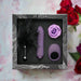 The "Midnight Magic Couples' Sex Toy Gift Set" includes a feather tickler, textured vibrator, vibrating cock ring, and purple rose—an enticing gift set for couples, pictured with red roses and petals in the background.
