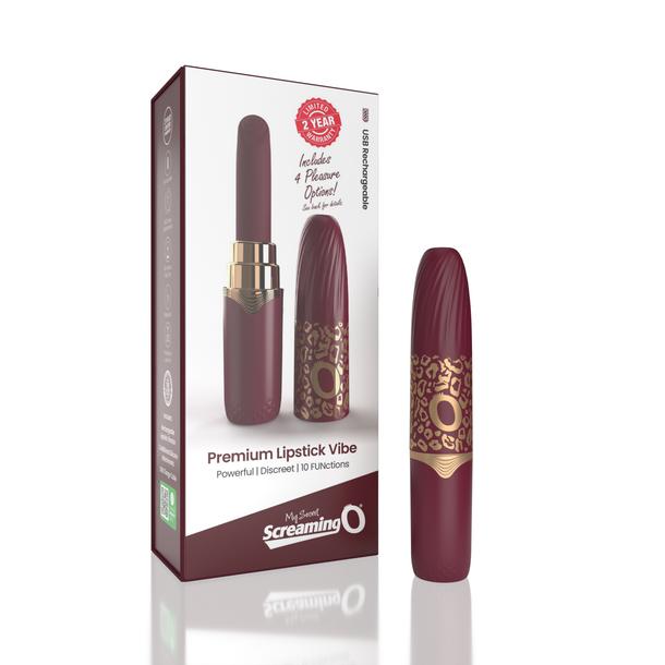 A burgundy and gold rechargeable massager sits next to its box labeled "My Secret Screaming O Premium Lipstick Vibrator," featuring product details and a two-year warranty seal on the discreet packaging.