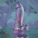 The Mythical Long Thick Vibrating Fantasy Dildo in Pastel Ombre, compatible with strap-on harnesses and featuring an iridescent purple and blue finish, stands upright on a reflective surface against a matching abstract background.