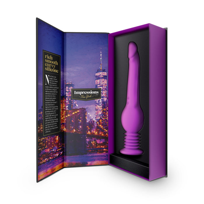 A purple New York Gyro Quake Thrusting 9.75 Inch Silicone Dildo from Blush is showcased in a sleek, black and purple box. The packaging, adorned with a nighttime cityscape featuring skyscrapers, emphasizes the product's waterproof capabilities and multiple vibrating modes. The word "Impressions" stands out prominently on the inside cover, highlighting its exceptional features.