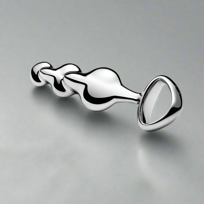 The Njoy Disco Weighted Stainless Steel Plug, featuring a chrome finish and a tapered handle with a multi-beaded design, is elegantly displayed against a plain white background, making it ideal for temperature play scenarios.