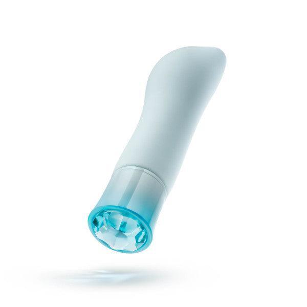 Introducing the luxurious **Oh My Gem Ardor Aquamarine Warming Internal & External Tapered Vibrator** from **Blush**. This sleek handheld device embodies elegance with its rounded, curved silicone body in white and light blue. Its transparent cylindrical base, tinted with a hint of blue, appears to illuminate slightly, giving off an ethereal glow. Pictured hovering in mid-air against a pristine white background, this vibrator is both a visual and functional masterpiece.
