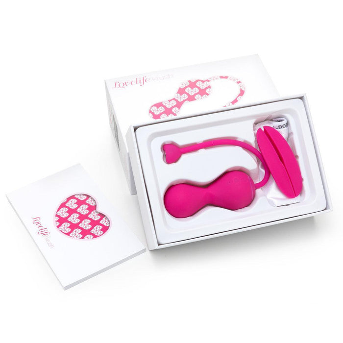 The image shows a box of OhMiBod Krush Smart Kegel Fitness Balls with Sensors, featuring a pink personal massager and remote for pelvic floor training. The packaging is adorned with heart motifs and prominently features the brand name "lovelife.