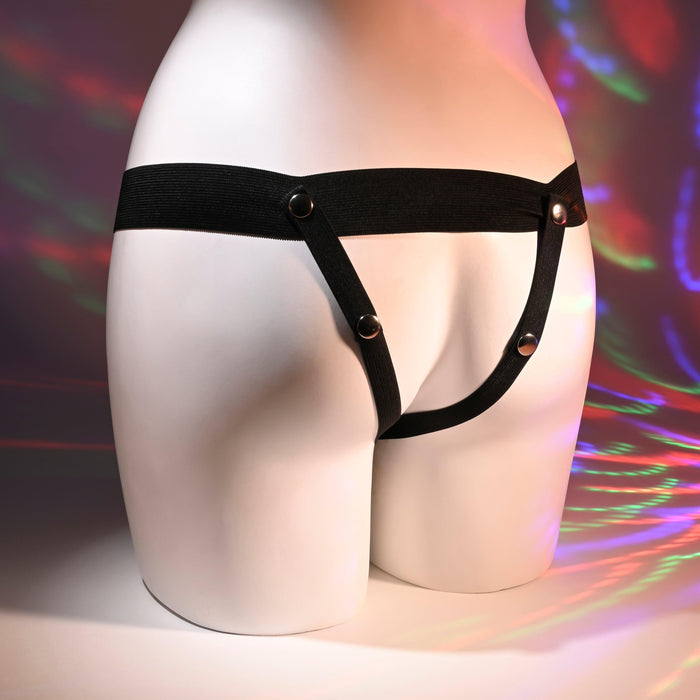A mannequin displays the Our First Hollow Strap-On Dildo + Harness Set in chocolate, amidst colorful light patterns, showcasing the latest in beginner fashion—ideal for those exploring playful versatility.