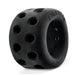 A black, cylindrical, rubber dog toy with multiple circular ventilation holes is shown. The toy has the word "Oxballs Air Lite Ventilated Ball Stretcher - Black Ice" embossed on its outer surface. The structure looks robust and designed for durability.