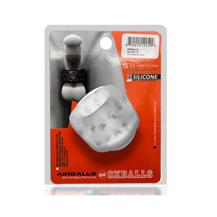 The Oxballs Ball Stretcher or Penetration Bumper, made of white plus+SILICONE, is shown in packaging with a black and white image of the product in use and branding details on an orange background.
