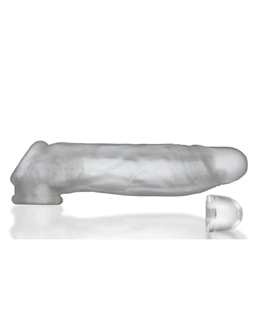 A translucent gray Oxballs Dicker 7.5 Inch Cock Sheath - Clear Ice in the shape of an erect penis, featuring textured veins and a separate detachable tip. The sleeve, designed for a slimmer fit sheath, is shown on a reflective white surface, highlighting its smooth and slightly shiny texture.