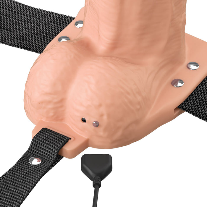 A close-up of the Fantasy X-Tensions Elite Vibrating Hollow 8 Inch Silicone Dildo & Strap-On Harness - Vanilla, featuring a realistic penis sleeve, harness, and attached charging cable.
