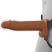 A person wears the Fantasy X-Tensions Elite Vibrating Hollow 8 Inch Silicone Dildo & Strap-On Harness in Chocolate, shown from the side against a plain background.