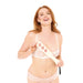 A smiling woman with long red hair models a sheer white bra and matching underwear, holding the Peaches 'n Cream Impression Paddle with cartoon faces, set against a plain white background.