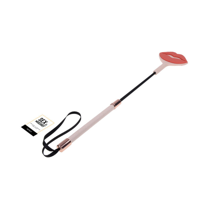 The Peaches 'n Cream Silicone Kiss Crop features a playful pink silicone lip tip, white handle, black wrist strap, and a "Sex & Mischief" tag near the handle for a flirty finishing touch.