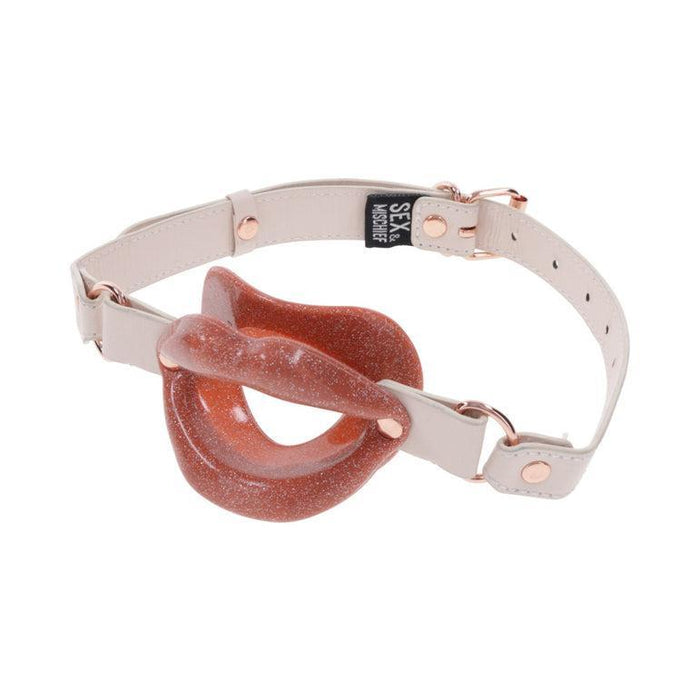 The Peaches 'n Cream Silicone Lips Open Mouth Gag by Sportsheets features a rose-gold and pink faux leather harness with a sparkling, interlocking silicone design, ideal for kinky play. The harness is equipped with adjustable straps and metal buckles to ensure a comfortable fit.