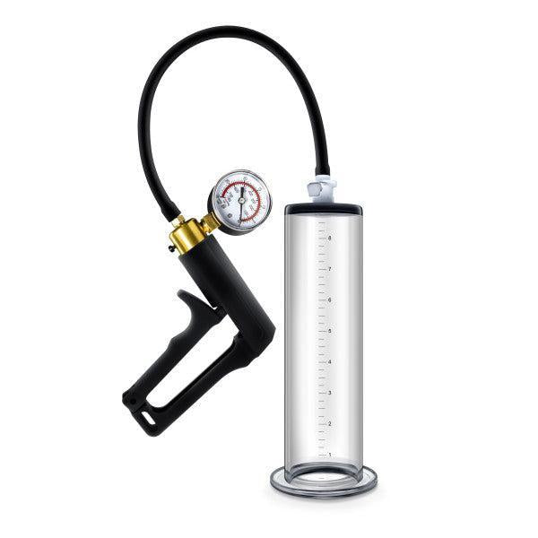 The Blush Performance VX7 Vacuum Penis Pump is a transparent cylindrical device featuring a black handle and an attached flexible tube. It includes a pressure gauge to display pressure levels, and the cylinder is marked with measurements for precision. The handle is equipped with a brass trigger for manual operation.