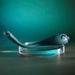 The Pinpoint Perfection Flexible Slim Vibrator is a sleek, teal, body-safe silicone toy with a circular button on one end, shown on a clear round stand against a gradient teal background.