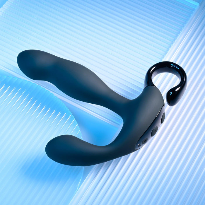 The Playboy Come Hither Motion Vibrating Prostate Massager by Evolved Novelties is a dual-ended silicone personal massager with a curved, ergonomic design, featuring control buttons and a loop handle for easy grip. It offers 10 vibration speeds and rests on a blue and white ribbed surface.