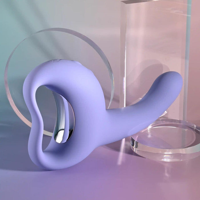 The Playboy Nice to Meet You Powerful Thrusting Vibrator with Handle in purple rests on a table.