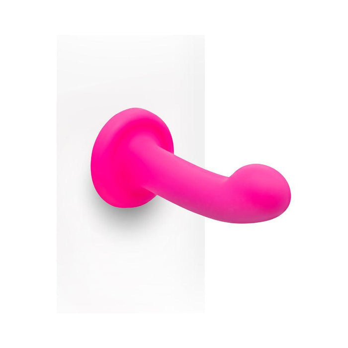 The Pop Strap on Dildo & Harness Set in Pink Silicone features a 5-inch smooth, curved dildo with a sturdy suction cup for hands-free use or pairing with the included harness—perfect for versatile solo or partnered play.