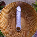 The Purple Fantasy Veiny Silicone Vibrator with Finger Loop, flexible and USB magnetic rechargeable, sits on a textured, honeycomb-patterned golden plate. It's safe silicone body is surrounded by green plants and dark red flowers against a gray background.
