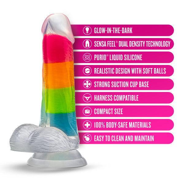 The Rainbow Rave Glow in the Dark 6.5 Inch Silicone Dildo by Blush, featuring a rainbow-colored design and a strong suction cup base, is accompanied by a list of features: glow-in-the-dark capability, dual density technology for added realism, crafted from liquid silicone with a realistic design for a more lifelike feel, harness compatibility, compact size for convenience, made from body-safe materials, and easy to clean.