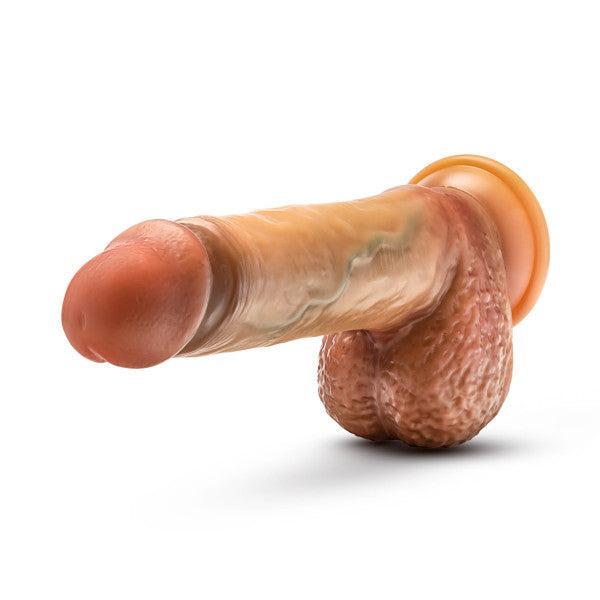Introducing the Raphael Ultra Realistic 9.5 Inch Silicone Dildo with Sliding Foreskin - Caramel by Blush: a lifelike dildo designed to mimic a human penis. Featuring a rich caramel tone, visible veins, testicles, and a strap-on compatible suction cup base, this dildo provides hands-free versatility for all your intimate needs.