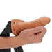 Caramel Realrock 6 Inch Hollow Dildo & Strap-on Harness being held by a hand on a white background