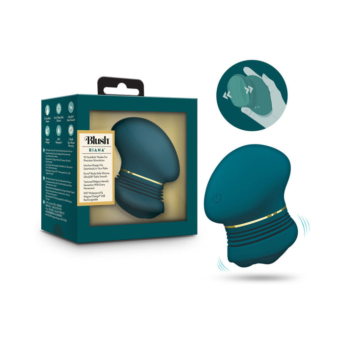 The Riana Circular Clitoral Rubbing Vibrator, made from body-safe dark teal silicone with gold accents, is shown beside its packaging. An illustration highlights its ergonomic shape and size while held in a hand.