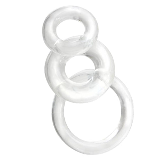 Three translucent, clear glass cock rings from the Screaming O Ringo 3 piece Cock Ring Set - Clear are stacked vertically, with the smallest ring at the top, a medium-sized ring in the middle, and the largest ring at the bottom. The rings are evenly spaced apart against a white background.