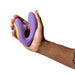 A hand holds the Romp Reverb Pleasure Air Vibrator for G-Spot & Clitoris, shown in purple and yellow against a white background.