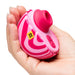 A hand holds the Romp Spin Small Discreet Pleasure Air Clitoral Stimulator—a pink and white striped, travel-size device with a round opening, two buttons, and a yellow "RIP" sticker.