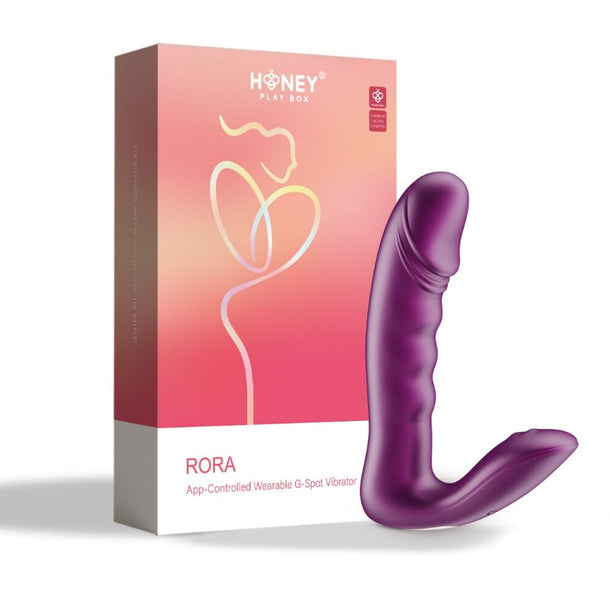 The Rora 2 App-Controlled Rotating G-Spot Vibrator & Clit Stimulator by Honey Play Box, made of body-safe silicone, is shown in purple beside its pink and orange packaging, offering comfortable and discreet pleasure with app-controlled features.