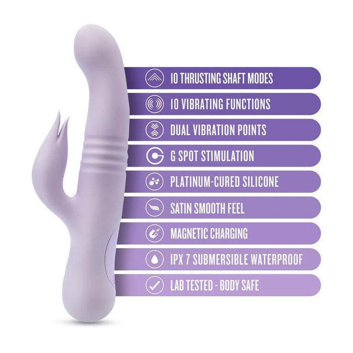The Rylee Clit Fluttering G-Spot Thrusting Rabbit by Blush is a lavender-colored silicone vibrator with a curved shape and an additional stimulator designed for clitoral massaging. It boasts 10 thrusting shaft modes, G-spot stimulation, 10 vibrating functions, dual vibration points, platinum-cured silicone for a satin smooth feel, magnetic charging capabilities, and an IPX 7 submersible waterproof design. Plus, it is lab-tested to ensure body safety.