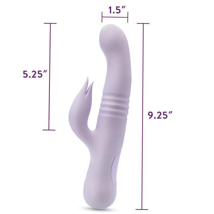 Introducing the Rylee Clit Fluttering G-Spot Thrusting Rabbit by Blush, a light purple vibrator designed for dual stimulation with a smooth, curved aesthetic. The main shaft is 9.25 inches long and 1.5 inches wide, ideal for G-spot pleasure, while the secondary arm measures 5.25 inches in length to massage the clitoris effectively. Measurement indicators and text are conveniently placed next to the toy for easy reference.