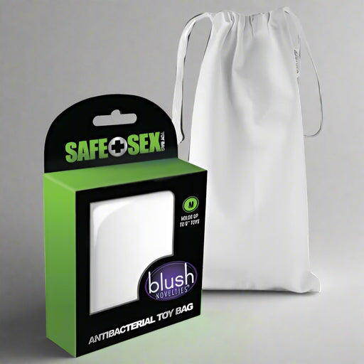 Beside a plain, lint-free drawstring bag is a white package with green and black accents labeled "Blush Novelties," showcasing the Safe Sex Antibacterial Toy Bag - Medium, designed for sleek and safe storage.