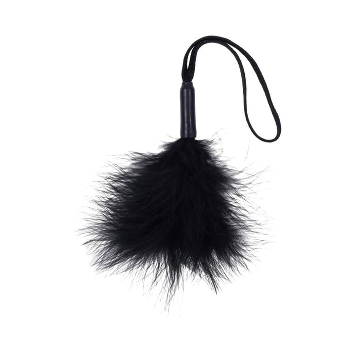 The Sex & Mischief Black Wrist Feather Tickler features a fluffy black feather end, compact handle, and looped strap—ideal for sensory play and a chic addition to your black accessories. Shown isolated on a white background.