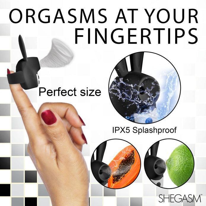 A person’s hand, adorned with red nail polish, holds a small black Shegasm Sucky Bunny Beginner Clit Stimulator made of body-safe silicone on their fingertip. Text above reads, "ORGASMS AT YOUR FINGERTIPS." Various labels and images describe the stimulator as "Perfect size," "IPX5 Splashproof," and show it in use on an orange and a lime. The brand name XR Brands is at the center.